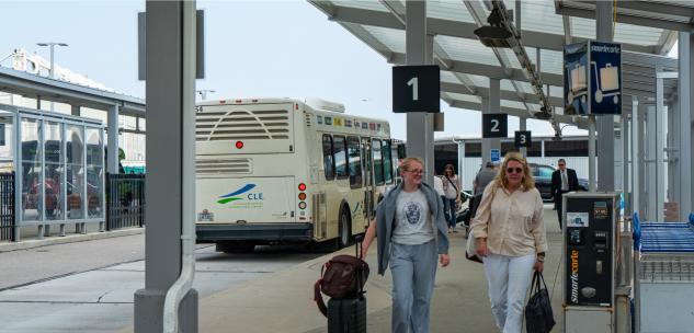two women walking towards the airport from the ground transportation center