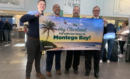 Employees holding a banner announcing Frontier flying to Montego Bay