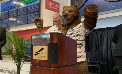 Frontier mascot speaking at a podium in front of ticketing
