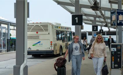 two women walking towards the airport from the ground transportation center